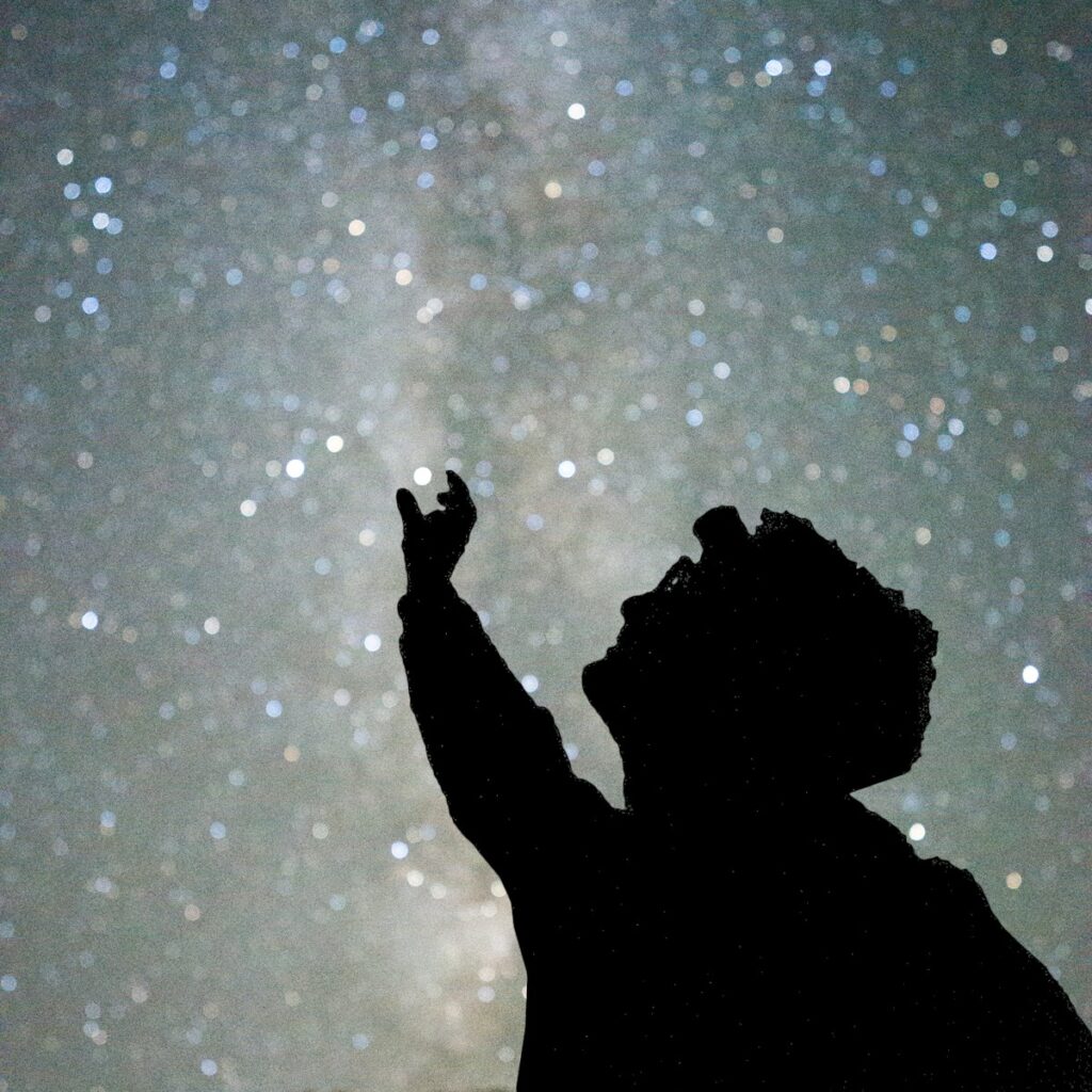 silhouette of man under starry night