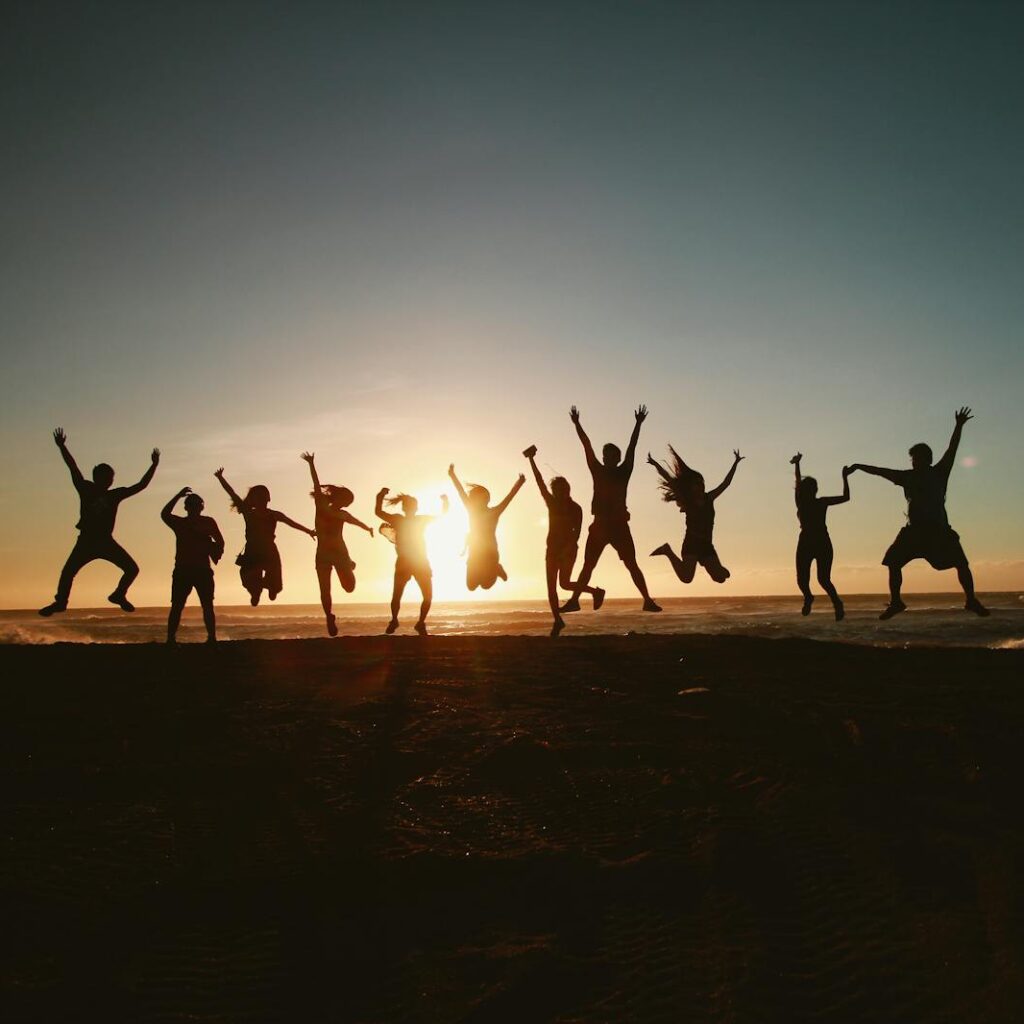 Silhouette Photography of Group of People Jumping during Golden Time